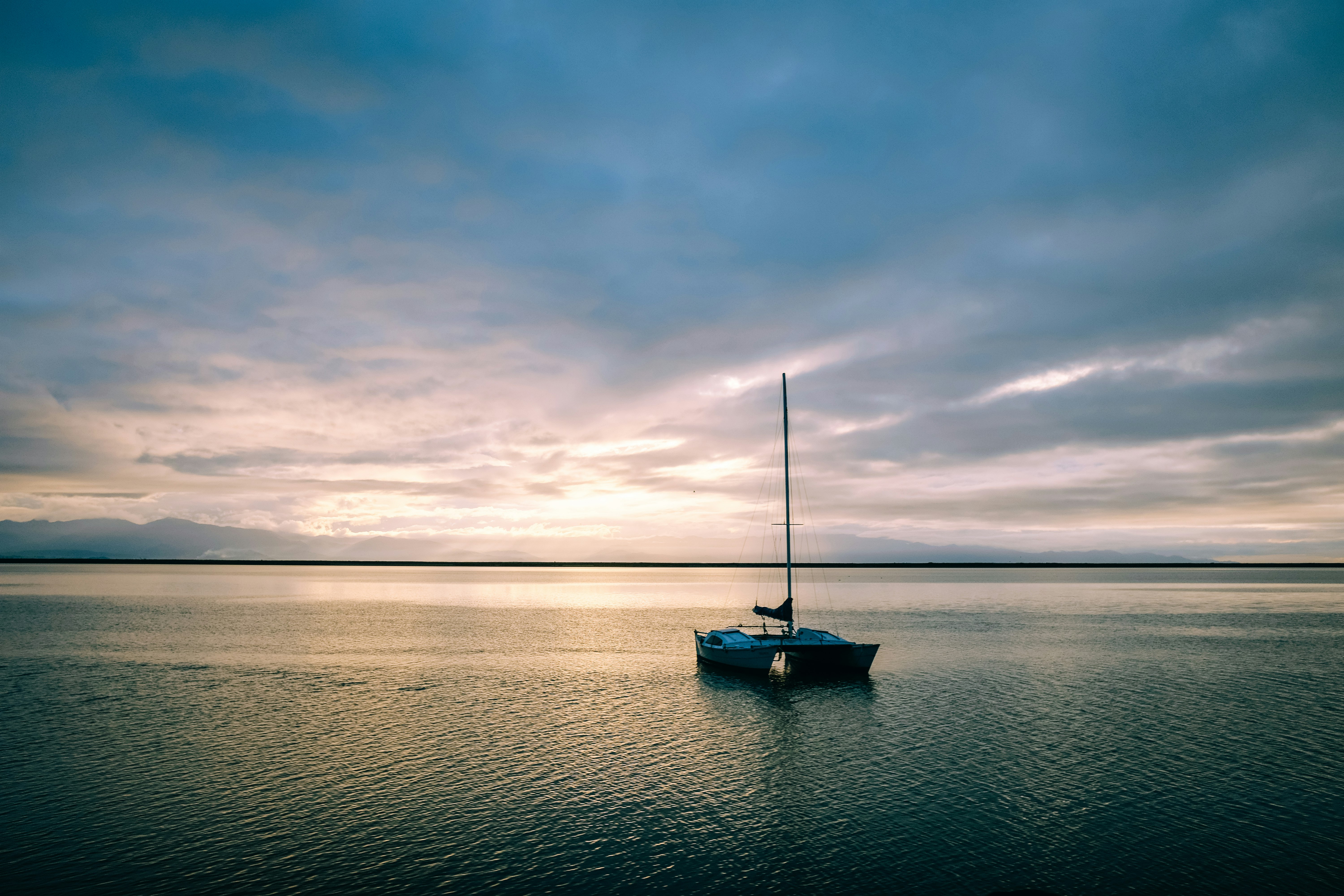 boat on sea under cloudy sky during daytime